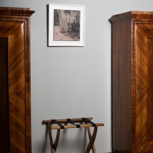 'Exotic memories' de Sabina Elena Dragomir, expusă cu grație pe un perete între două dulapuri elegante din lemn, armonizând cu decorul sofisticat din lemn al camerei.