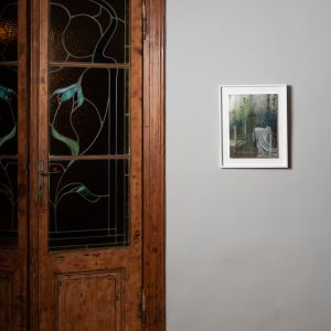 'Early rain' de Sabina Elena Dragomir, expusă elegant lângă o ușă din lemn într-o cameră cu o atmosferă nostalgică.